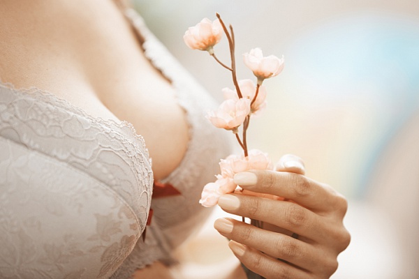 Девушка в бюстгальтере с цветком в руке