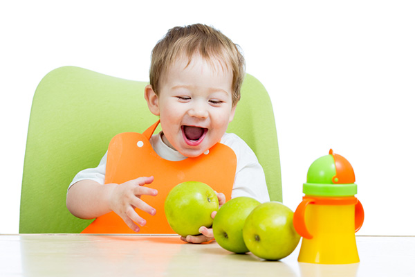 Ребенок впервые кушает яблоко