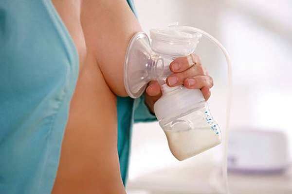 Женщина сцеживает грудное молоко